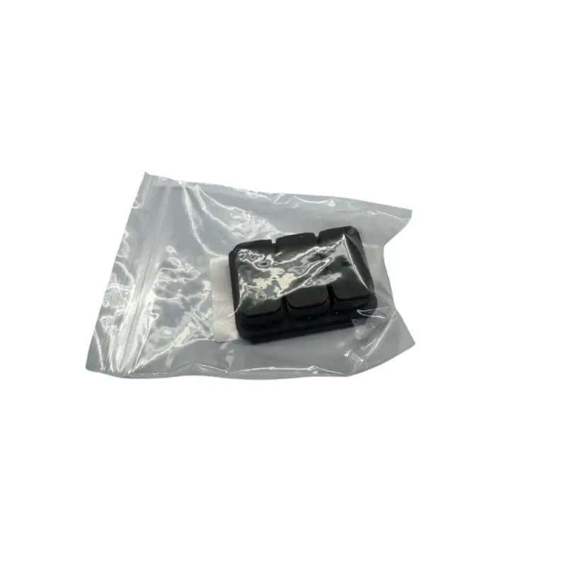 Black rubber keyboard keycaps in a plastic bag.
